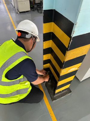 Kỹ sư kiểm định kiểm tra cột nhà xưởng tại khu vực va chạm