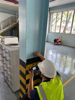 Kỹ sư kiểm định tiến hành đo đạc cột kết cấu tại khu vực nhà xưởng để đánh giá an toàn chịu lực