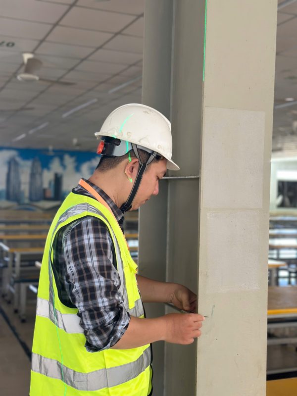 Kỹ sư kiểm định đang kiểm tra an toàn chịu lực kết cấu nhà xưởng tại công trình.