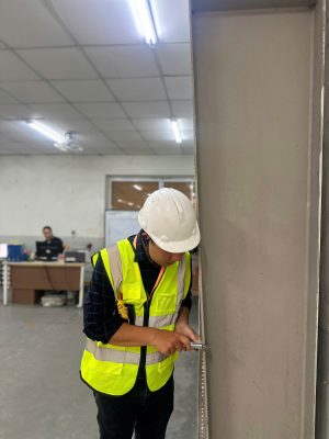 Kỹ sư kiểm định đang đo và đánh giá hiện trạng cột bê tông nhà xưởng.