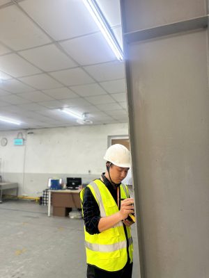 Kỹ sư kiểm định đang kiểm tra hiện trạng cột bê tông trong nhà xưởng đang hoạt động.