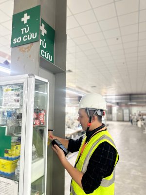 Kỹ sư kiểm định khảo sát khu vực lối thoát hiểm và cột kết cấu trong nhà xưởng sản xuất.