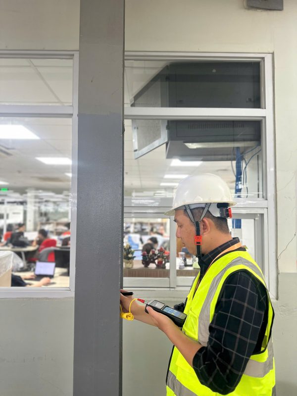 Kỹ sư kiểm định khảo sát hiện trạng kết cấu và không gian làm việc trong nhà xưởng sản xuất.