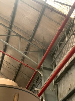 ALT: Kiểm tra chi tiết kết cấu mái thép và hệ thống kỹ thuật treo dưới mái nhà xưởng công nghiệp.