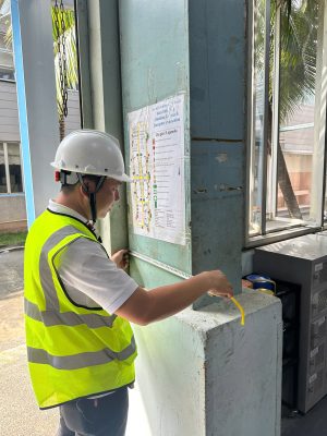 Kỹ sư kiểm định đối chiếu hồ sơ và kiểm tra hiện trạng kết cấu cột nhà xưởng tại hiện trường.