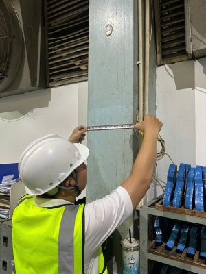 Kỹ sư kiểm định đo kiểm kích thước và độ thẳng cột kết cấu nhà xưởng.