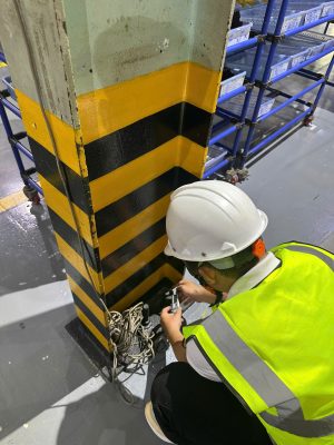 Kỹ sư kiểm định kiểm tra hiện trạng chân cột nhà xưởng tại khu vực có nguy cơ va chạm.