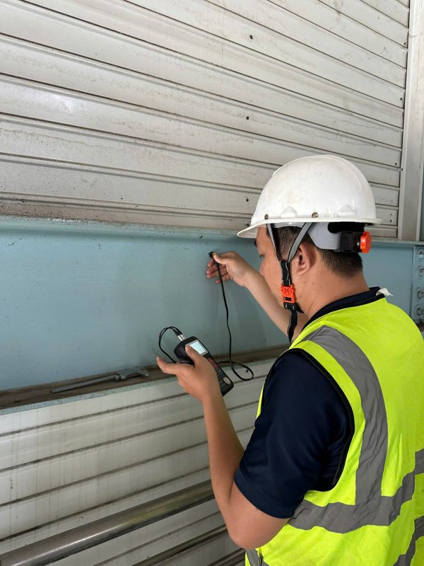 Kiểm tra hiện trạng cửa cuốn nhà xưởng trong quá trình kiểm định chất lượng công trình.