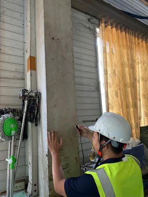 Kiểm tra hiện trạng cột và vách nhà xưởng tại khu vực cửa cuốn trong quá trình kiểm định.