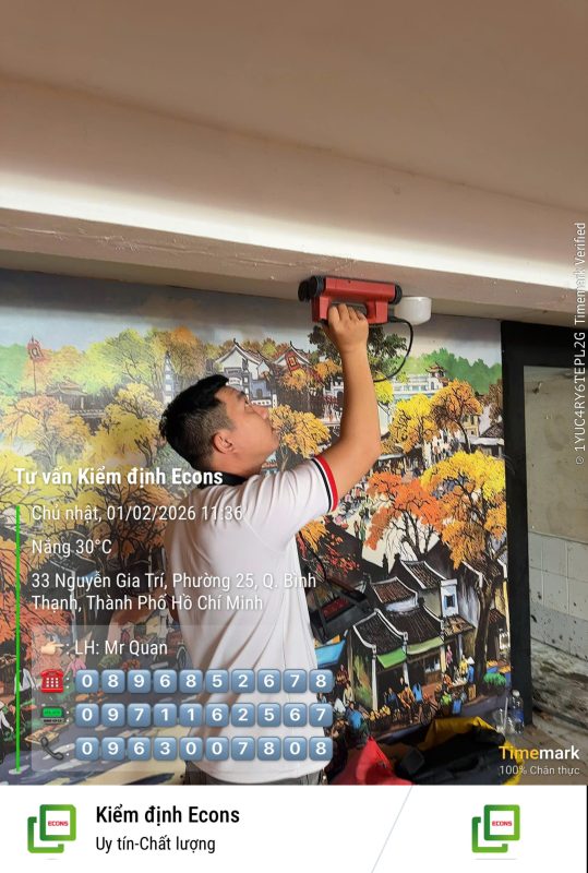 Kỹ sư kiểm định sử dụng thiết bị đo kiểm tra hiện trạng trần bê tông trong quá trình kiểm định chất lượng công trình.