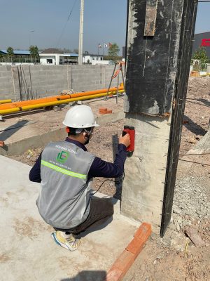 Kỹ sư kiểm định thực hiện kiểm tra hiện trạng nền móng và cấu kiện bê tông ngoài hiện trường trong kiểm định định kỳ công trình.