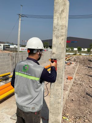 Kỹ sư kiểm định cột bê tông tại hiện trường công trình.