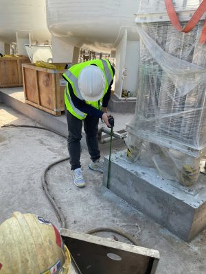 Kỹ sư kiểm định kiểm tra hiện trạng khu vực móng và đế thiết bị trong nhà xưởng.