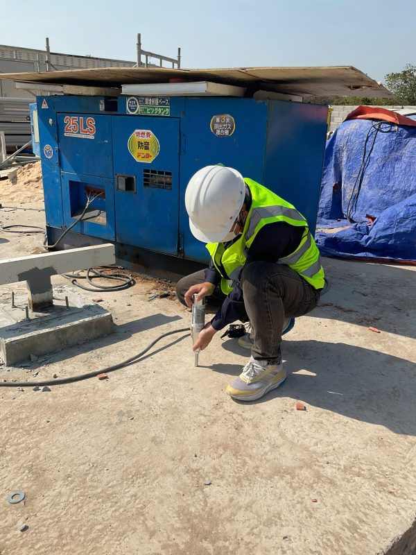 Kỹ sư kiểm định kiểm tra hiện trạng khu vực kỹ thuật và nền móng trong nhà xưởng.