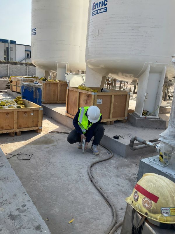 Kỹ sư kiểm định kiểm tra hiện trạng nền và khu vực kỹ thuật trong nhà xưởng.