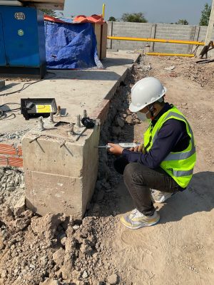 Kỹ sư kiểm định kiểm tra hiện trạng nền và khu vực móng trong nhà xưởng.