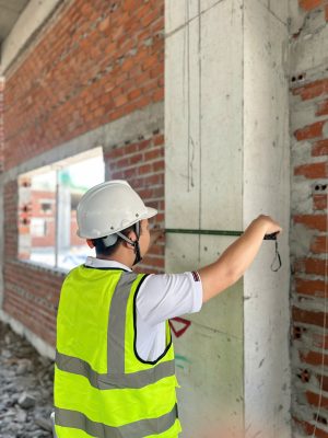 Đo kiểm kích thước cột bê tông trong quá trình kiểm định chất lượng công trình.