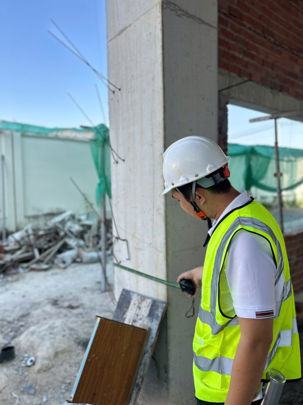 Đo kiểm kích thước cột bê tông trong công tác kiểm định chứng nhận an toàn công trình.