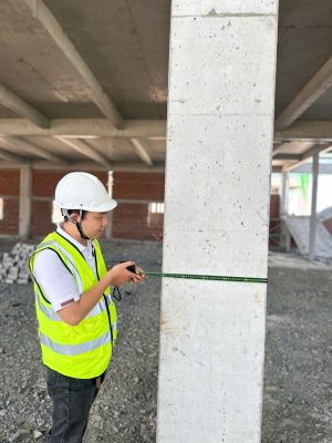Kiểm tra kích thước hình học cột bê tông trong quá trình kiểm định chứng nhận an toàn nhà xưởng.
