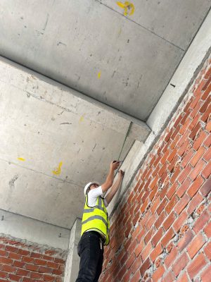 Khảo sát bề mặt dầm bê tông và tường xây trong quá trình đánh giá an toàn nhà xưởng.