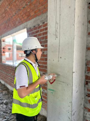 Kiểm định đo độ thẳng đứng và kích thước cột bê tông nhà xưởng bằng thước chuyên dụng.