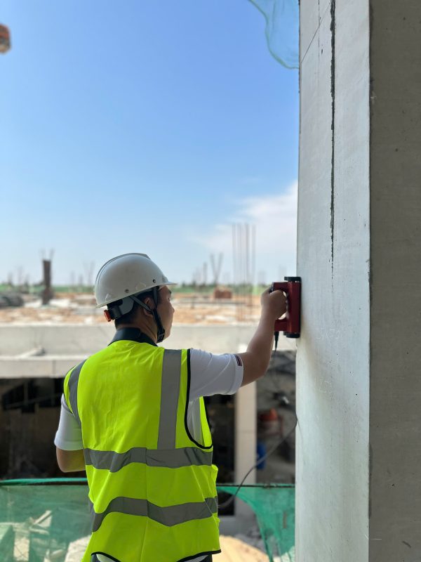 Kỹ sư đang dò thép trong kết cấu bê tông bằng máy dò cốt thép phục vụ công tác kiểm định.