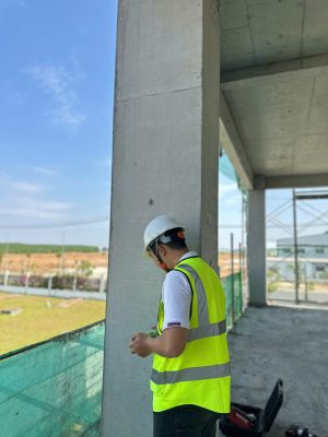 Kỹ sư kiểm định đang kiểm tra chất lượng bê tông bằng máy siêu âm và thiết bị thí nghiệm không phá hủy.