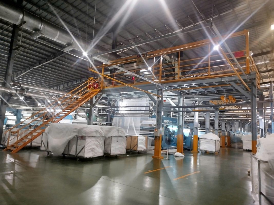 Hình ảnh nhà máy sản xuất bên trong nhà xưởng công nghiệp với hệ kết cấu thép và dây chuyền sản xuất. Kiểm định nhà xưởng giúp đánh giá khả năng chịu lực kết cấu và đảm bảo an toàn vận hành trong quá trình sản xuất.